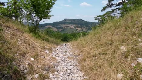 Pov-walking-a-rocky-path-towards-an-edge-with-perfect-view-on-franconian-mountain-"Staffelberg