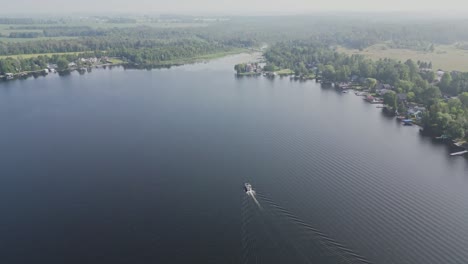Aerial-View-Over-Calm-Lake-With-Boat-Sailing---drone-shot