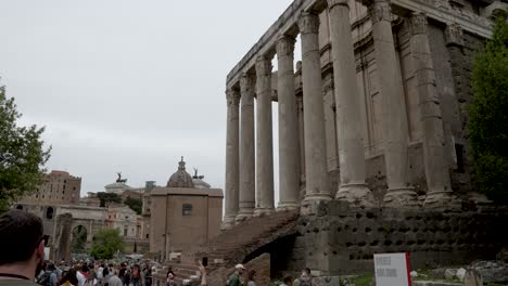 Einspielung-Des-Eingangs-Zum-Wunderschönen-Tempel-Des-Antoninus-Und-Der-Faustina,-Der-Sich-Nach-Unten-Neigt,-Um-Die-Massen-Von-Touristen-Zu-Zeigen,-Die-Das-Berühmte-Wahrzeichen-Von-Rom,-Italien,-Besuchen