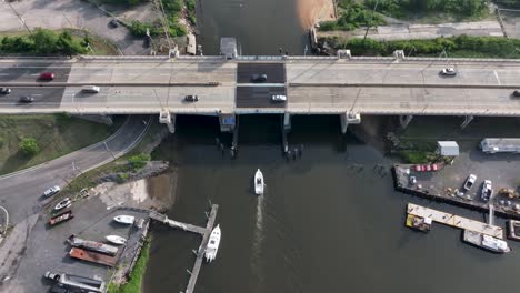 Aerial-view-of-Boat-passing-beneath-Route-35-Bridge-going-over-Cheesequake-Creek-in-NJ