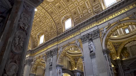A-shot-angled-at-the-ceiling-of-the-famous-St-Peter's-Basilica,-the-golden-mosaics,-sculptures-and-art-makes-the-church-a-popular-sightseeing-tourist-attraction-in-Rome,-Italy