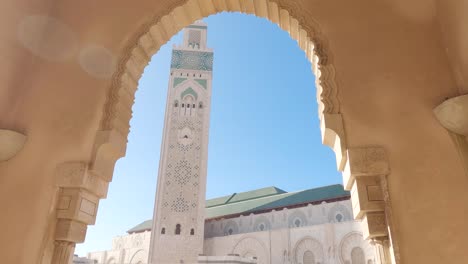 Looking-up-through-decorative-archway-to-Hassan-ii-mosque-marble-Moroccan-tower-architecture
