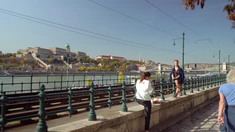 A-girl-posing-for-the-photograph-at-pedestrian-walkway-overlooking-at-Buda-Castle-alongside-Danube-river,-gimbal-shot