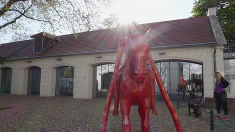 Modern-red-horse-sculpture-lit-from-behind-in-contemporary-art-Kampa-Museum,-Prague