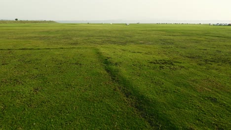 Aerial-view-shot-of-Landscape-at-the-end-of-Pa-Sak-Jolasid-Dam-with-green-grass-and-water
