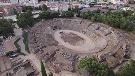 Aerial-view-Roman-Amphitheatre-ruins-of-Merida,-orbiting-shot-above-ancient-performance-archaeology