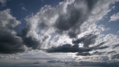 Aerial-left-to-right-shot-sky-with-dark-grey-clouds-covering-sun-foggy-landscape