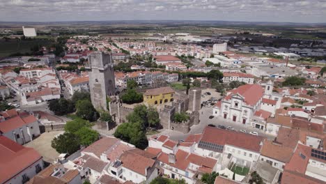 Castle-Beja-old-defensive-tower-aerial-view-circling-Baixo-Alentejo-whitewashed-red-tiled-rooftops,-Portugal-cityscape