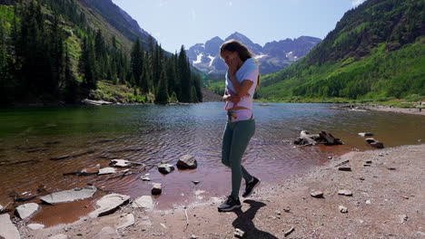 Maroon-Bells-Aspen-Snowmass-wilderness-hike-shoreline-crystal-clear-lake-women-female-model-actress-in-awe-14er-Capital-peaks-Rocky-Mountains-Colorado-summer-stunning-morning-cinematic-follow-backward