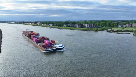 Fully-loaded-container-ship-sailing-on-river,-Aerial-view