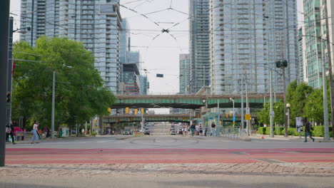 Vista-De-La-Calle-Urbana-Del-Centro-De-Toronto,-Ciclistas-Pasando-En-Primer-Plano