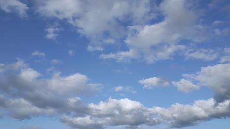 Statische-Kamera,-Graue-Wolken,-Die-Sich-Langsam-über-Den-Blauen-Himmel-Bewegen,-Keine-Sonne,-Keine-Landschaft
