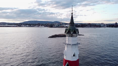 Kavringen-fyr-lighthouse-at-Inner-Oslo-Fjord-and-city-in-background-at-sunset