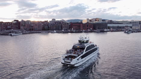 Aerial-tracking-shot-of-ferry-sailing-on-Oslo-coast-at-dusk
