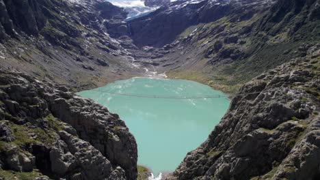 Aerial-Flyover-of-Triftbrucke-with-Turquoise-Trift-Lake-and-Glacier-View