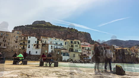 Time-Lapse-of-a-tourists-on-the-coast-or-beach-of-Sicily-with-hills-and-buildings-at-background-in-Italy