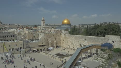 Aerial-view-of-People-at-Jerusalem-Western-wall,-a-known-worship-place-for-Jewish-people-and-the-Dome-of-the-rock-in-the-background