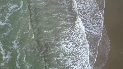 Luftaufnahme-Von-Oben-Mit-Drohnenansicht-Der-Wellen,-Die-Am-Ufer-Des-Strandes-Von-General-Villamil-In-Ecuador-Plätschern