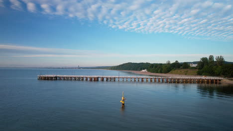 Scenic-aerial-riser-at-sunrise-of-wooden-Gdynia-Orlowo-Pier-in-Bay-of-Gdansk
