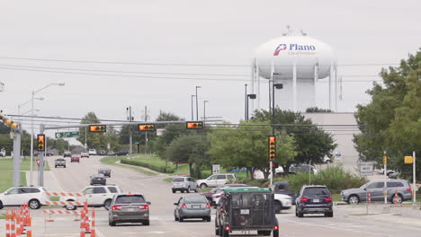 A-busy-intersection-in-front-of-a-water-tower-in-Plano,-Texas