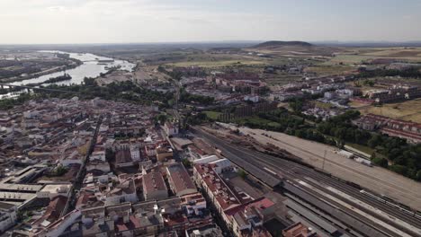Aerial-view-orbiting-the-city-of-Merida,-Spain,-alongside-Guadiana-river-and-skyline-of-the-Badajoz-province