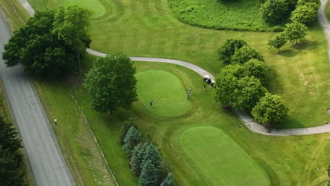 Bird's-eye-view-of-golfer-ready-to-swing,-panning-aerial-shot-in-golf-course
