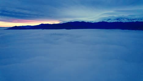 Aerial-Drone-Fly-Above-the-Clouds-in-Andean-Cordillera-Mountain-Sunrise-Santiago-Chile,-Heaven-Like-Skyline-in-Blue-and-Golden-Gradient-Colors