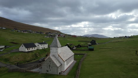Viðareiði-church,-Faroe-Islands:-aerial-view-traveling-in-over-the-church-of-this-village-in-the-Faroe-Islands