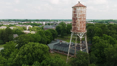 Establishing-aerial-of-old-water-tower-rising-in-Fort-Harrison-park-in-Lawrence
