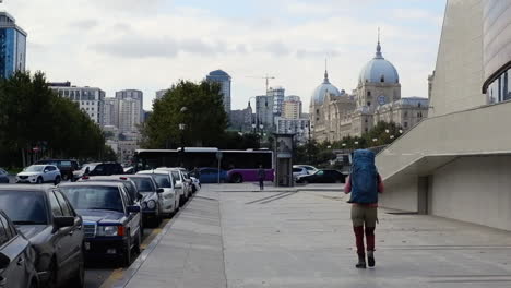 Traveler-walks-with-heavy-backpack-on-street-of-Baku,-Azerbaijan