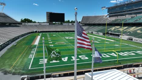 American-flag,-Colorado-flag,-and-Colorado-State-University-flags-waving-in-Canvas-Stadium