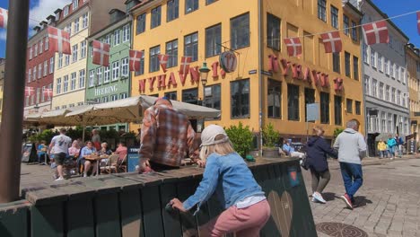 Touristen-Spazieren-Entlang-Der-Nyhavn-Uferpromenade,-Die-Von-Bars-Und-Restaurants-Gesäumt-Ist
