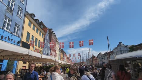 Tourists-walking-along-the-Nyhavn-waterfront-that-is-lined-with-bars-and-restaurants