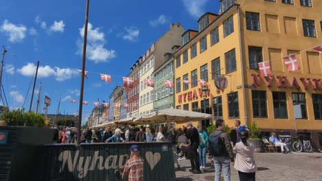 Tourists-walking-along-the-Nyhavn-waterfront-that-is-lined-with-bars-and-restaurants