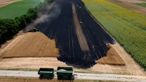Tractor-Trying-To-Contain-The-Fire-On-Agricultural-Field---aerial-drone-shot
