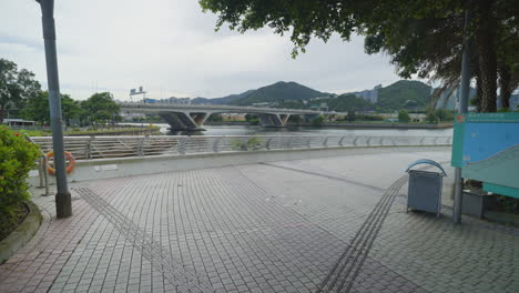 Dolly-Schiebt-Sich-Durch-Den-Park-In-Richtung-Geländer-Am-Flussufer-In-Hongkong