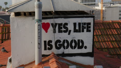Yes,-Life-Is-Good-Sign-Behind-The-Chimney-In-Lisbon,-Portugal