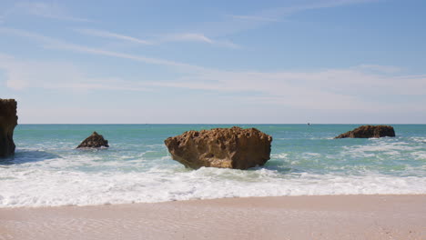 Olas-Del-Océano-Rompiendo-En-Las-Rocas-De-La-Playa-En-Algarve,-Portugal