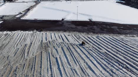 Yellow-Snowplow-Clearing-Huge-Snow-Field,-Winter,-City-of-Ottawa,-Wide-Establishing-Aerial