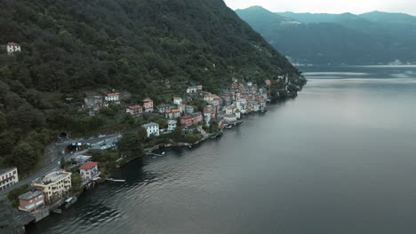 View-of-Brienno-town-along-scenic-coast-of-Lake-Como,-Italy,-as-seen-from-flying-drone
