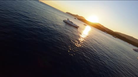 Malerische-FPV-Luftaufnahme,-Die-über-Luxusyachten-Auf-Ibiza-In-Richtung-Der-Untergehenden-Sonne-Fliegt