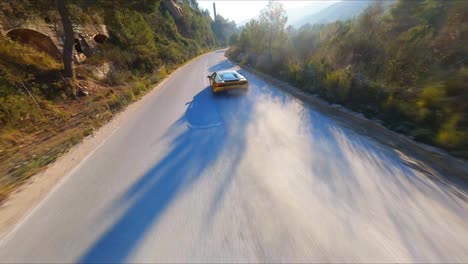 Fantastische-FPV-Luftdrohne,-Die-Einem-Gelben-Lamborghini-Auf-Einer-Landstraße-In-Spanien-Folgt