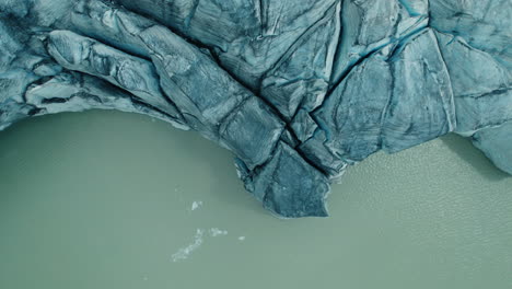 Glacier-Melting-in-a-lake-below-due-to-Climate-Change-in-the-Alps,-view-from-above