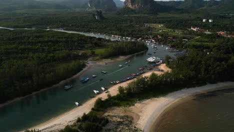 Luftaufnahme-Des-Flusses-Mit-Vielen-Vor-Anker-Liegenden-Booten-Im-Hafen-Von-Ao-Nang-Und-Malerischer-Landschaft-Im-Hintergrund-–-Wunderschöner-Sandstrand-Von-Thailand