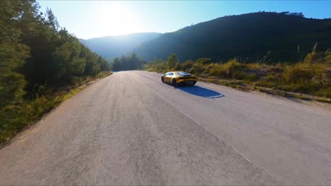 FPV-Luftdrohne-Verfolgt-Einen-Atemberaubenden-Gelben-Lamborghini-Entlang-Einer-Malerischen-Autobahn