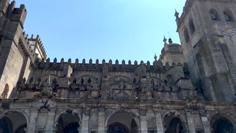 Schwenkaufnahme-Der-Berühmten-Kathedrale-Von-Porto-Vor-Blauem-Himmel-Im-Sonnenlicht-In-Porto,-Portugal-–-Ansicht-Von-Unten