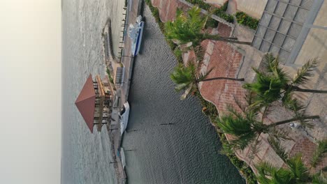 Vertikale-Drohnenaufnahme-Des-Hotels-Hilton-Garden-Inn-Mit-Jachthafen-Und-Steg-Bei-Sonnenaufgang---La-Romana,-Dominikanische-Republik