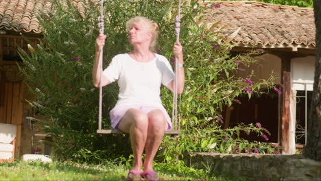Woman-enjoys-garden-swing-in-peaceful-solitude-on-beautiful-summer-morning
