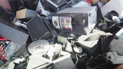 Discarded-electronics-dumped-haphazardly-at-disposal-center,-closeup-slider