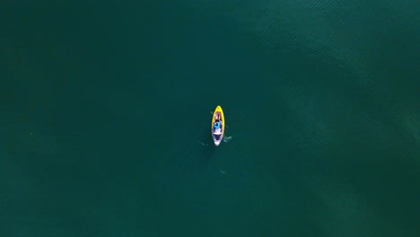 Stunning-aerial-4K-drone-footage-of-a-kayaker-paddling-through-a-tranquil-lake